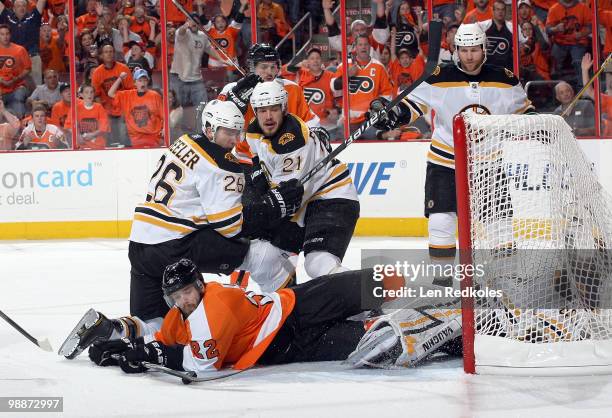 Ville Leino of the Philadelphia Flyers attempts a shot from his stomach against Blake Wheeler, Andrew Ference and goaltender Tuukka Rask of the...