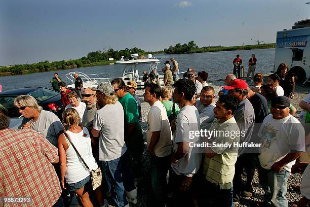 Unemployed commercial fishermen and their families wait in line to receive hand-outs from New Orleans Catholic Charities on May 5, 2010 in Hopedale,...