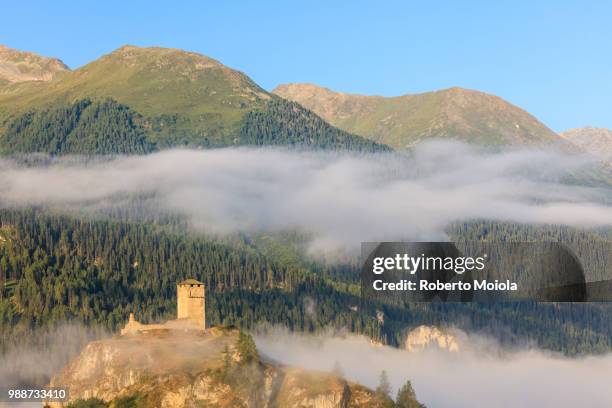 tower of steinsberg castle framed by woods, ardez, canton of graub?nden, district of inn, lower engadine, switzerland, europe - graubunden canton stock-fotos und bilder