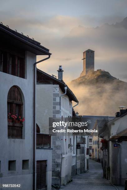 misty sky on the alpine village of ardez at sunrise, canton of graub?nden, district of inn, lower engadine, switzerland, europe - canton tower imagens e fotografias de stock