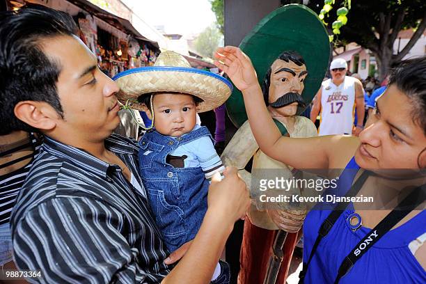 Griselda Vasquez, mother of seven month old Alexander Mendoza, puts a sombrero on her son as his father Alfonso Mendoza looks on during Cinco de Mayo...