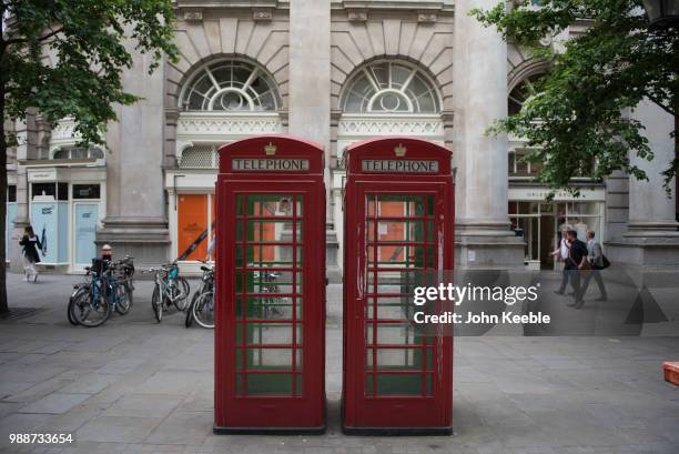 General view of two iconic traditional red phone boxes with gold royal crown on June 19, 2018 in London, England.