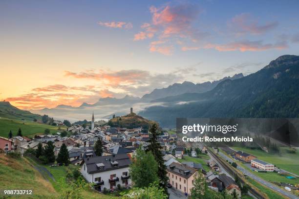 pink clouds at dawn on the alpine village of ardez, canton of graub?nden, district of inn, lower engadine, switzerland, europe - graubunden canton stockfoto's en -beelden