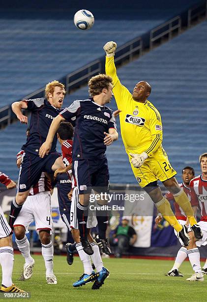 Zach Thornton of Chivas USA knocks away a kick as Pat Phelan and Zack Schilawski of the New England Revolution try to knock it in the goal on May 5,...