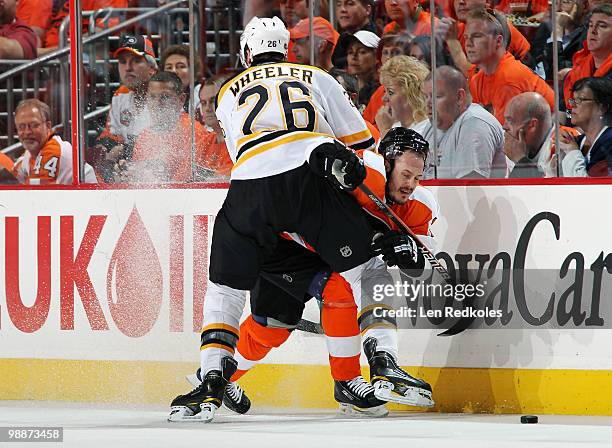 Blake Wheeler of the Boston Bruins pins Lukas Krajicek of the Philadelphia Flyers against the boards in Game Three of the Eastern Conference...