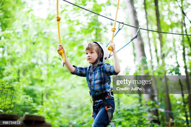 the little boy climbing in the rope park - carbine stock pictures, royalty-free photos & images