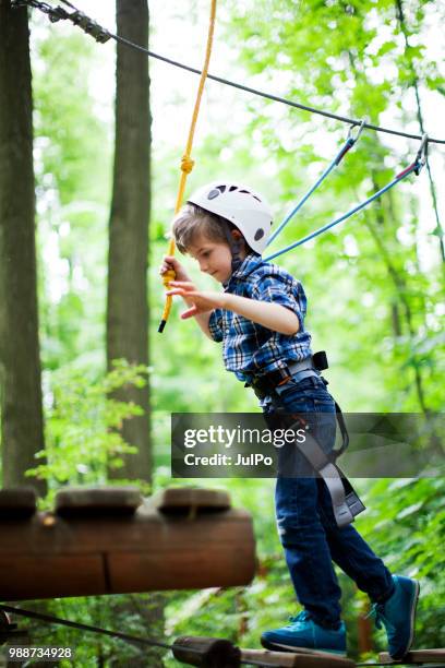 il bambino che si arrampica nel parco delle corde - carbine foto e immagini stock