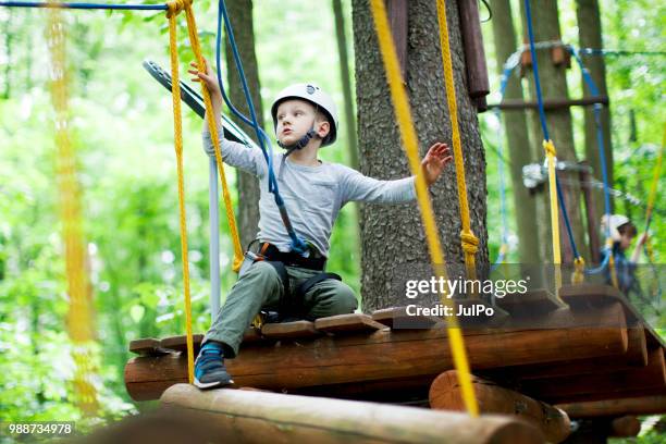 il bambino che si arrampica nel parco delle corde - carbine foto e immagini stock