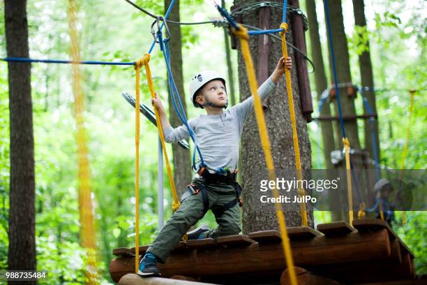 the little boy climbing in the rope park - carbine stock pictures, royalty-free photos & images