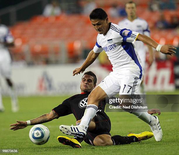 Santino Quaranta of D.C. United makes a slide tackle against Roger Espinoza of the Kansas City Wizards at RFK Stadium on May 5, 2010 in Washington,...