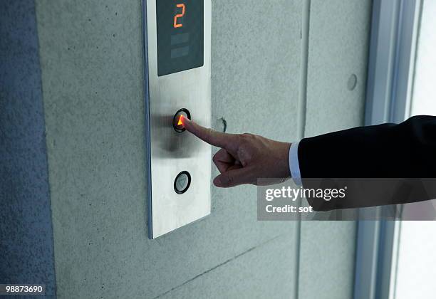 businessman pushing switch of elevator,close up - newbusiness stock pictures, royalty-free photos & images
