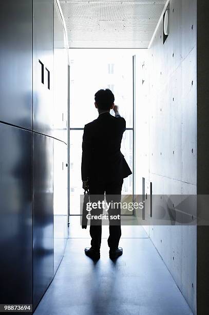 businessman standing in passage - newbusiness stock pictures, royalty-free photos & images
