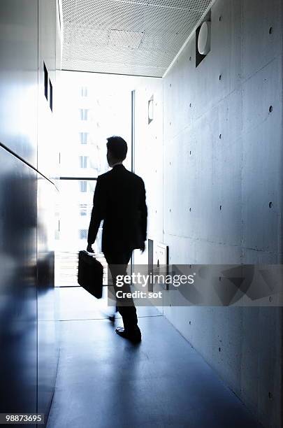 businessman walking in passage - newbusiness stock pictures, royalty-free photos & images