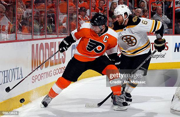 Mike Richards of the Philadelphia Flyers controls the puck against Dennis Wideman of the Boston Bruins in Game Three of the Eastern Conference...