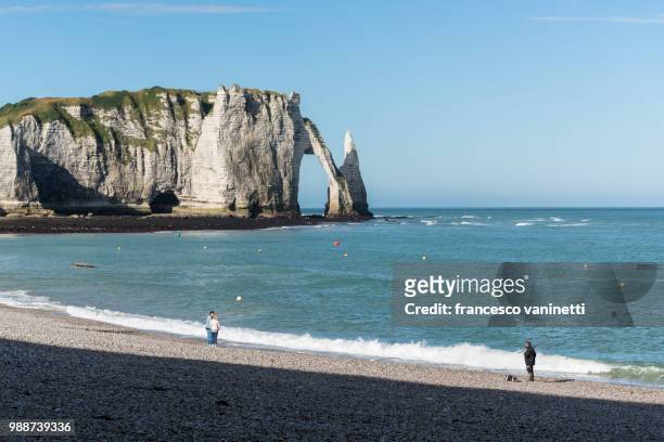 people on the beach and porte d'aval in the background, etretat, normandy, france, europe - ポルトダヴァル ストックフォトと画像
