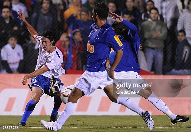 Uruguayan Nacional's Alvaro Gonzalez kicks the ball marked by Brazilian Cruzeiro's Henrique and Diego during their Libertadores Cup match at the Gran...