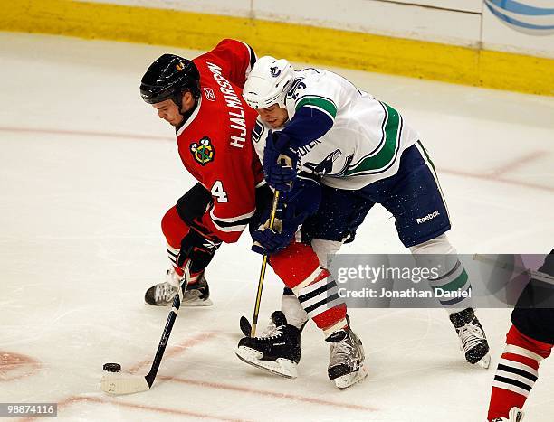 Niklas Hjalmarsson of the Chicago Blackhawks and Andrew Alberts of the Vancouver Canucks battle for the puck in Game Two of the Western Conference...