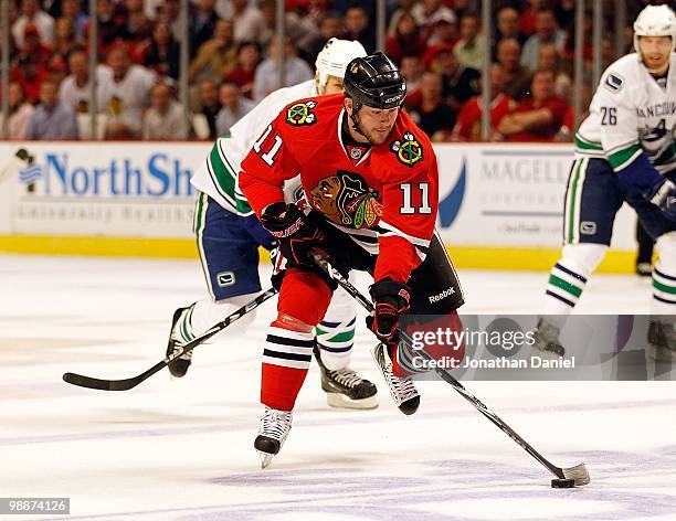 John Madden of the Chicago Blackhawks pushes the puck up the ice against the Vancouver Canucks in Game Two of the Western Conference Semifinals...