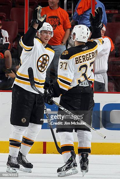 Blake Wheeler and Patrice Bergeron of the Boston Bruins celebrate after defeating the Philadelphia Flyers in Game Three of the Eastern Conference...