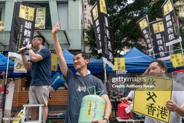 Protesters hold placards and shout slogans as they march on a street on July 1, 2018 in Hong Kong, Hong Kong. Hong Kong will mark 21 years since its...
