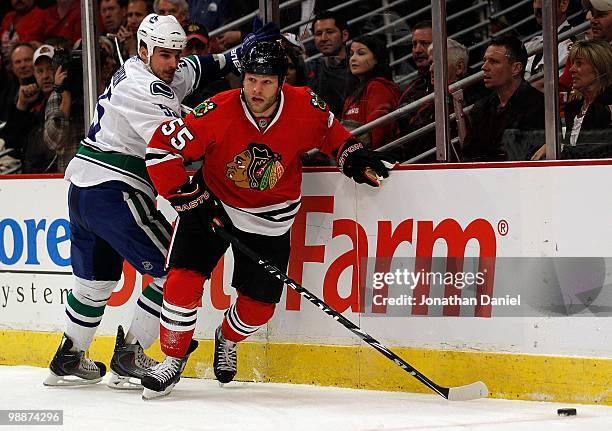 Ben Eager of the Chicago Blackhawks chases down the puck with Shane O'Brien of Vancouver Canucks in Game Two of the Western Conference Semifinals...