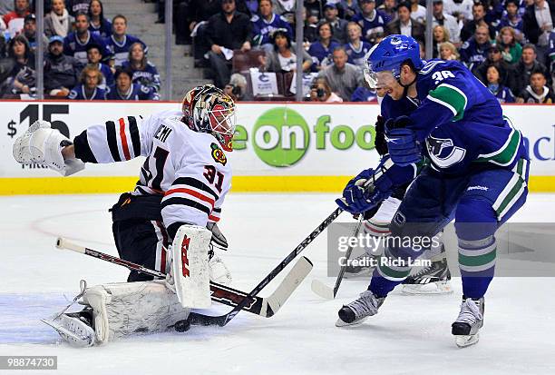 Goalie Antti Niemi of the Chicago Blackhawks stops Jannik Hansen of the Vancouver Canucks while on a break away during the first period in Game Three...