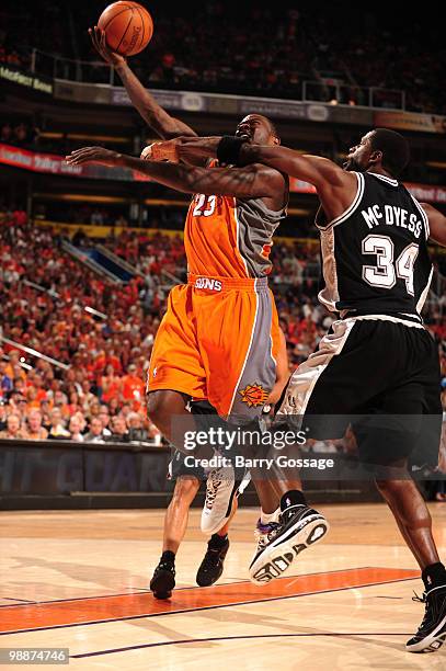 Jason Richardson of the Phoenix Suns is fouled by Antonio McDyess of the San Antonio Spurs on his way to the basket in Game Two of the Western...