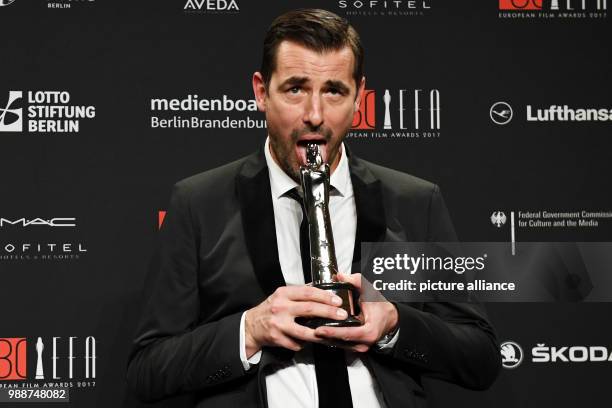 Actor Claes Bang holds the award for best actor for his performance in "The Square" after the 30th European Film Awards 2017 at Haus der Berliner...