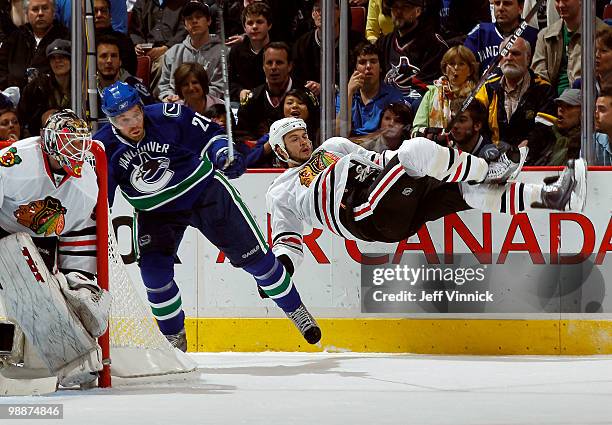 Goalie Antti Niemi of the Chicago Blackhawks looks on as Mikael Samuelsson of the Vancouver Canucks checks Brent Seabrook of the Chicago Blackhawks...