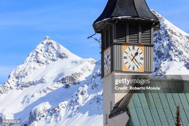 the typical alpine bell tower frames the snowy peaks, langwies, district of plessur, canton of graubunden, swiss alps, switzerland, europe - graubunden canton stock-fotos und bilder