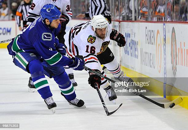 Kevin Bieksa of the Vancouver Canucks beats Andrew Ladd of the Chicago Blackhawks to the loose puck during the second period in Game Three of the...