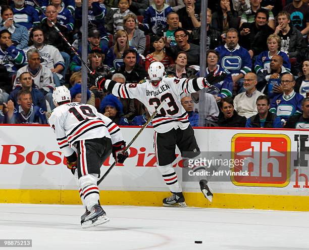 Patrick Sharp of the Chicago Blackhawks looks on as teammate Dustin Byfuglien yells to fans after scoring in Game Three of the Western Conference...