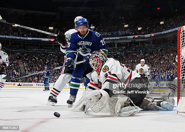 Goalie Antti Niemi of the Chicago Blackhawks dives to cover the puck from Mikael Samuelsson of the Vancouver Canucks in Game Three of the Western...