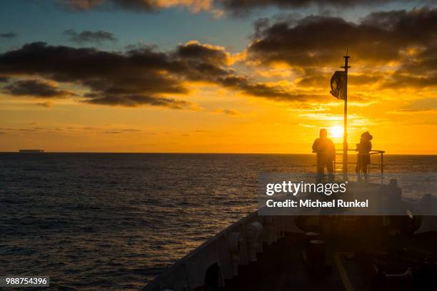 tourists standing on the bow of a cruise ship watching the sunset, south orkney islands, antarctica, polar regions - south orkney island stock pictures, royalty-free photos & images