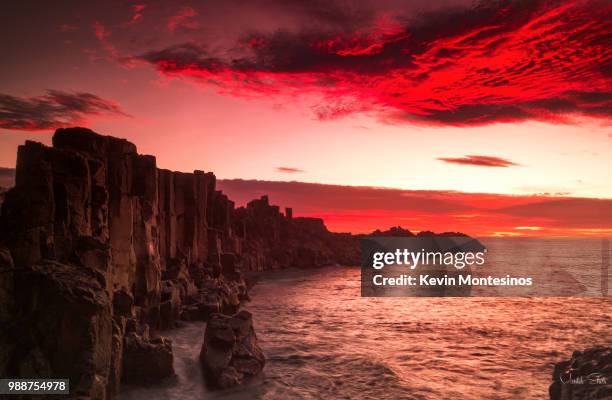 ocean cliffs at red dawn, kiama, new south wales, australia - kiama stock-fotos und bilder