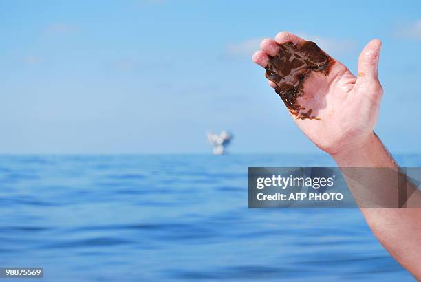 Charter boat captain William Bradford holds a glob of chemically dispersed oil floating in the Gulf of Mexico about 14 miles from the Venice marina...