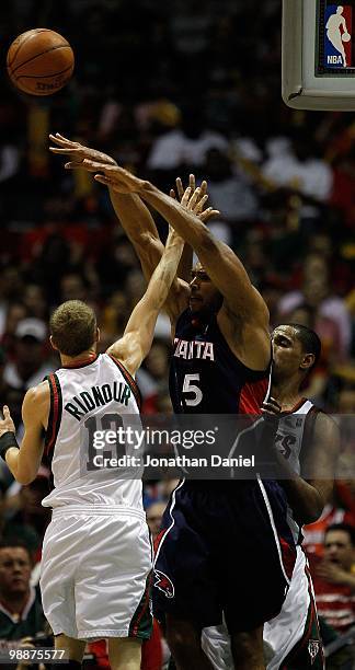 Al Horford of the Atlanta Hawks passes over Luke Ridnour of the Milwaukee Bucks in Game Six of the Eastern Conference Quarterfinals during the 2010...