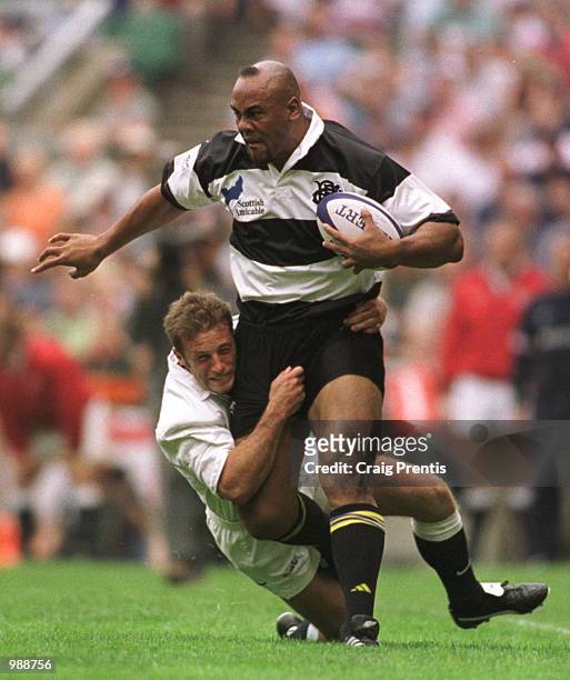 Jonah Lomu of the Barbarians is tackled by Paul Sampson of England during the match between England and the Barbarians played at Twickenham, London....