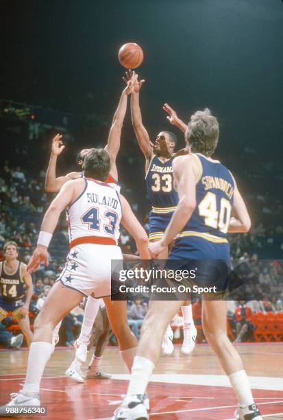 Clark Kellogg of the Indiana Pacers shoots over Greg Ballard of the Washington Bullets during an NBA basketball game circa 1984 at the Capital Centre...