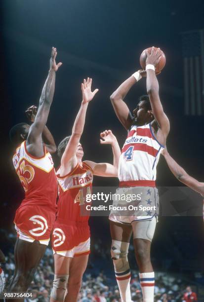 Cliff Robinson of the Washington Bullets shoots over Antoine Carr and Scott Hastings of the Atlanta Hawks during an NBA basketball game circa 1985 at...