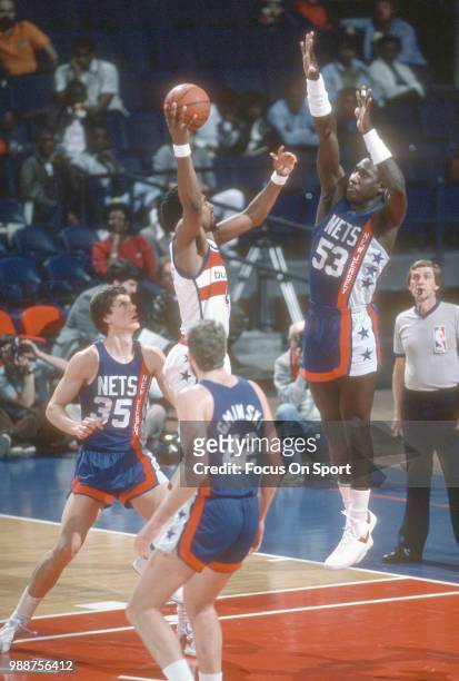 Cliff Robinson of the Washington Bullets shoots over Darryl Dawkins of the New Jersey Nets during an NBA basketball game circa 1985 at the Capital...