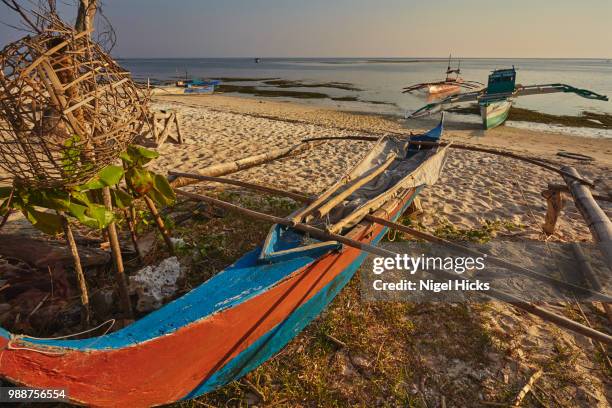 fishing boats pulled up onto paliton beach, siquijor, philippines, southeast asia, asia - island of siquijor stock pictures, royalty-free photos & images