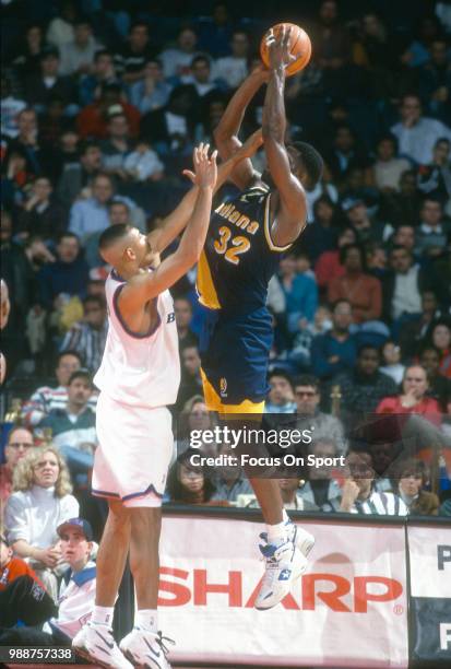 Dale Davis of the Indiana Pacers shoots over Juwan Howard of the Washington Bullets during an NBA basketball game circa 1995 at the US Airways Arena...