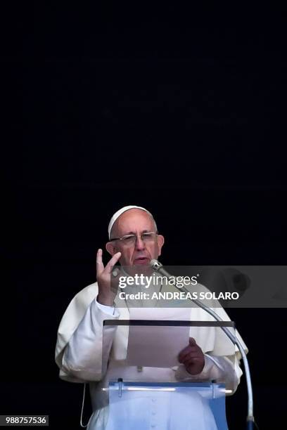 Pope Francis delivers his speech to the crowd from the window of the apostolic palace overlooking St Peter's square during the Sunday Angelus prayer,...