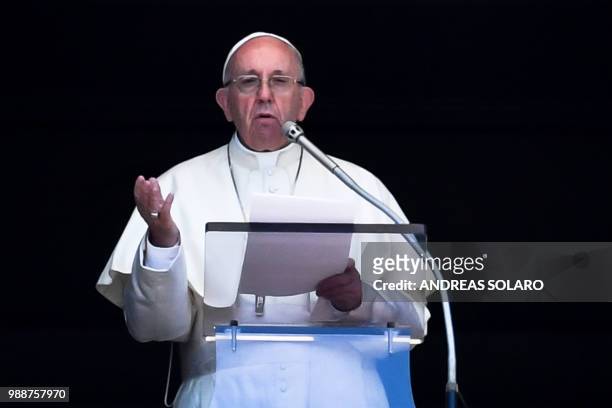 Pope Francis delivers his speech to the crowd from the window of the apostolic palace overlooking St Peter's square during the Sunday Angelus prayer,...