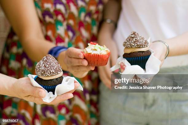 three ladies hold their yummy cupcakes - yummy stock pictures, royalty-free photos & images