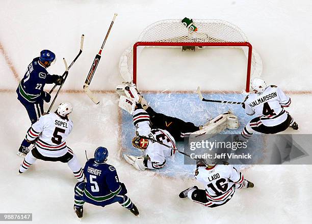 Antti Niemi of the Chicago Blackhawks makes a save off the shot of Mikael Samuelsson of the Vancouver Canucks as Christian Ehrhoff of the Vancouver...