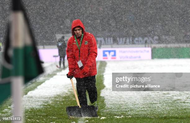 Helpers freeing the sidelines from snow during the German Bundesliga soccer match between Hannover 96 and 1899 Hoffenheim in the HDI Arena in...