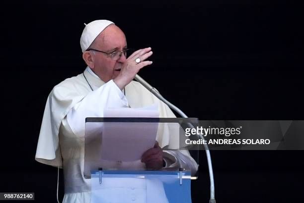 Pope Francis blesses the crowd from the window of the apostolic palace overlooking St Peter's square during the Sunday Angelus prayer, on July 1,...