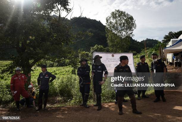 Thai soldiers and rescue workers stand by the junction leading up to Tham Luang cave at the Khun Nam Nang Non Forest Park in the Mae Sai district of...